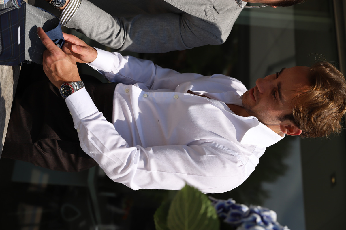 Man wearing a white Amarcord shirt looking at fabrics