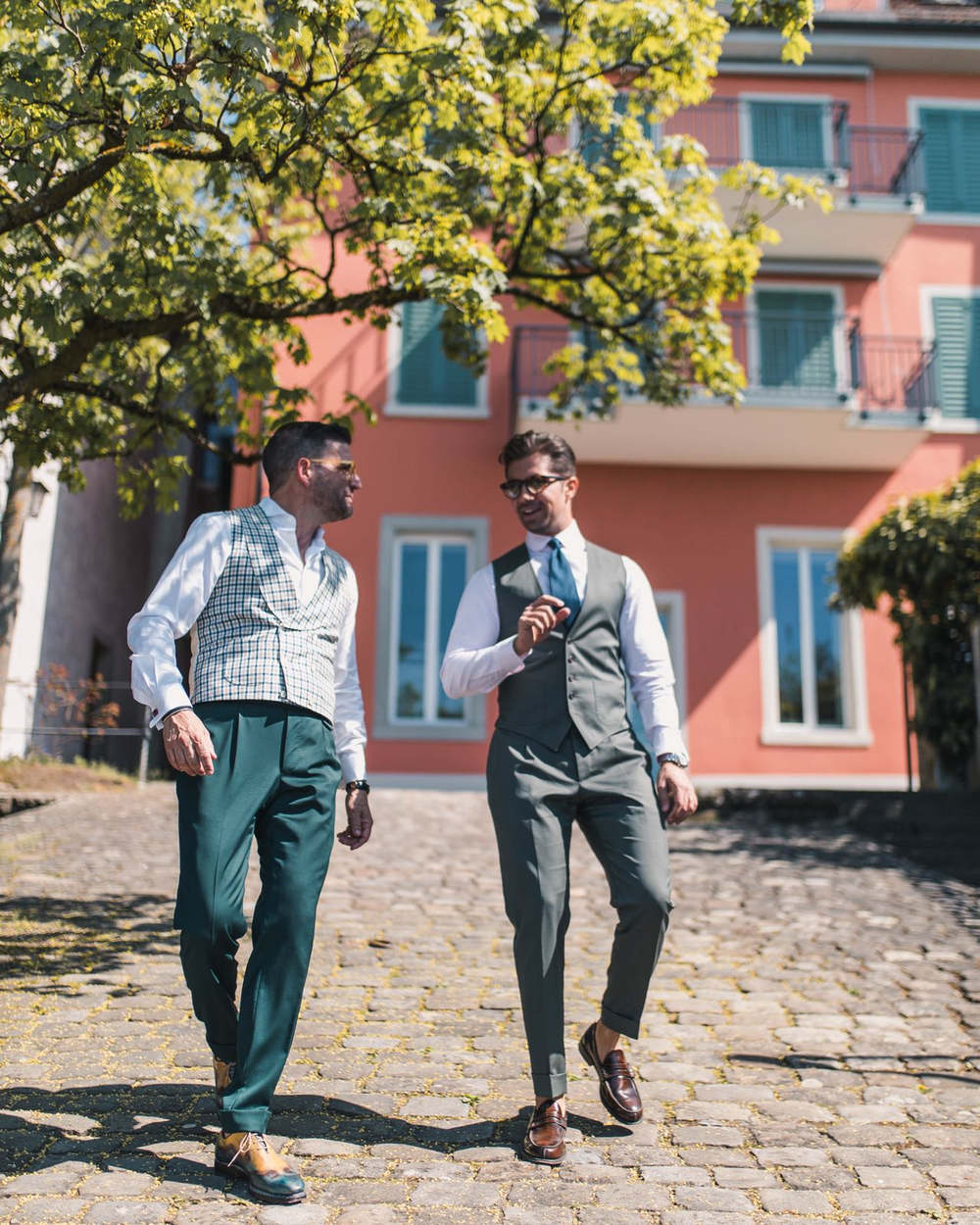 Two men walking down the road wearing Amarcord suits