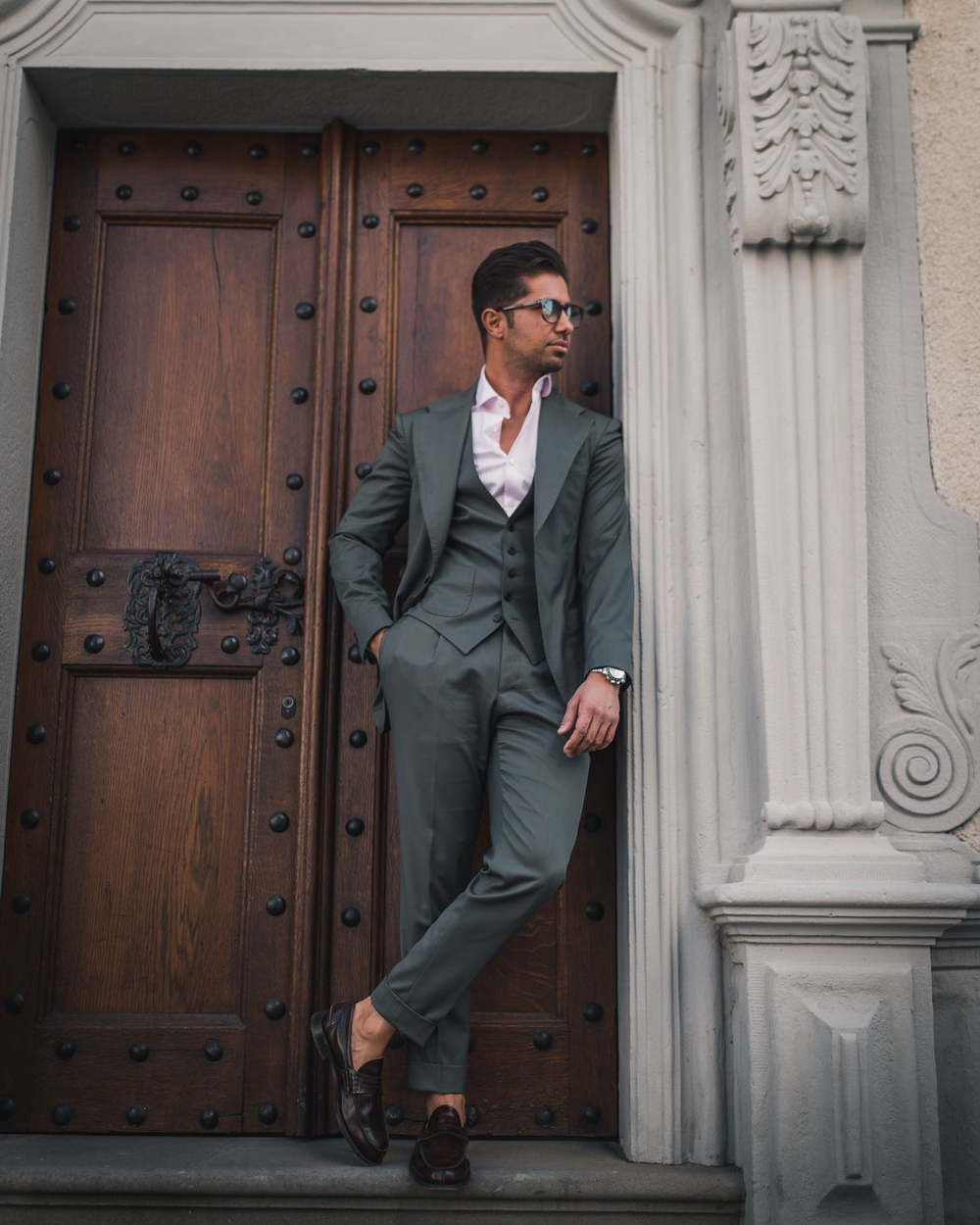 Classy man standing in doorway wearing an Amarcord suit